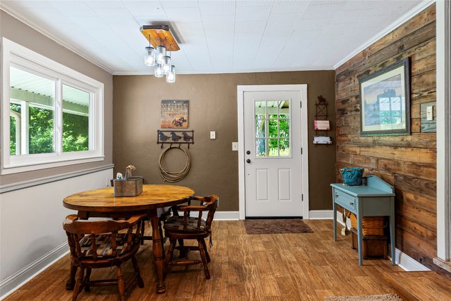 Dining room with plenty of natural light, crown molding, wood finished floors, and wooden walls | Image 8