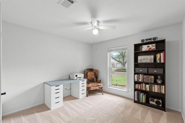 This room features a large window for natural light, neutral walls, and carpet for a versatile space. | Image 24