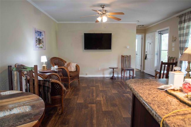 Open concept Living area with baseboards, a ceiling fan, ornamental molding, and dark wood finished floors | Image 25