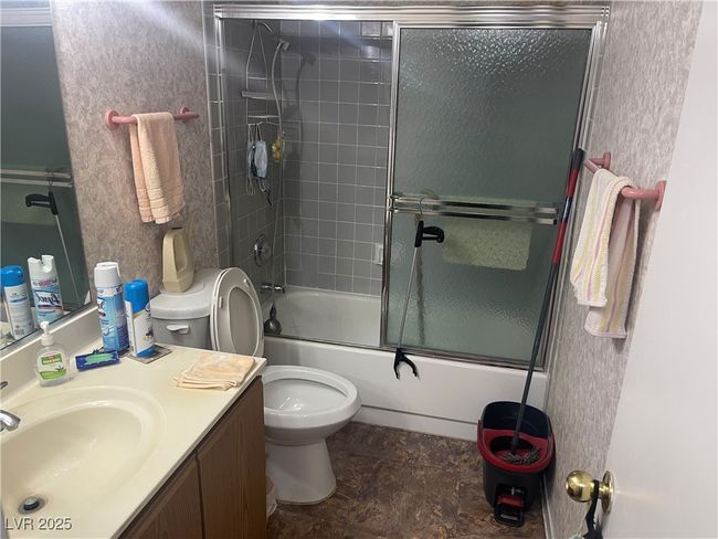 Bathroom with vanity, toilet, and bath / shower combo with glass door | Image 7
