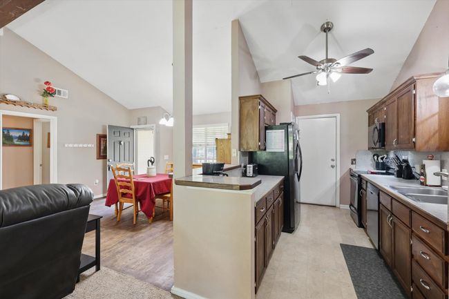 Kitchen featuring stainless steel appliances, a ceiling fan, a sink, light wood-type flooring, and open floor plan | Image 12