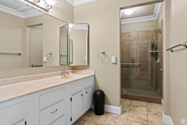 Bathroom featuring crown molding, vanity, and a shower stall | Image 23