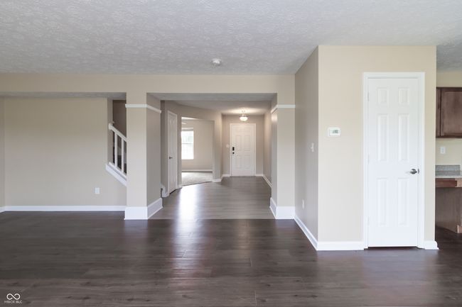 foyer featuring dark wood-style floors, stairway, and a textured ceiling | Image 7