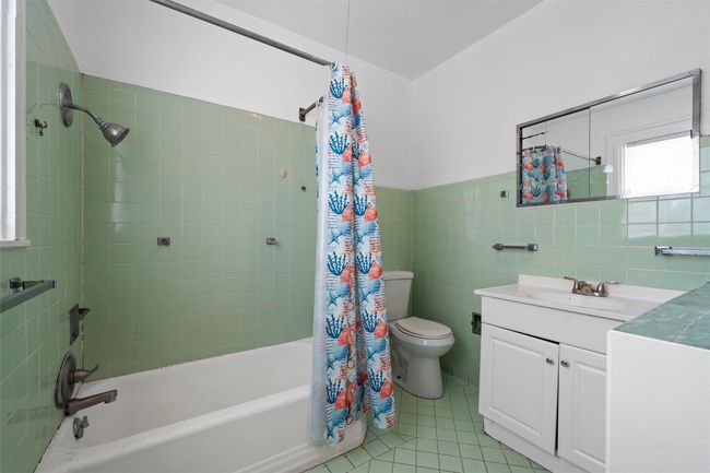 Full bath featuring vanity, tile walls, shower / tub combo, and tile patterned flooring | Image 30