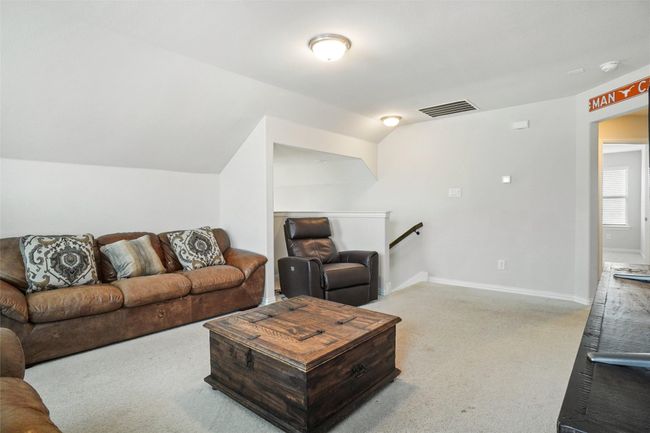 Carpeted living area featuring vaulted ceiling and baseboards | Image 20