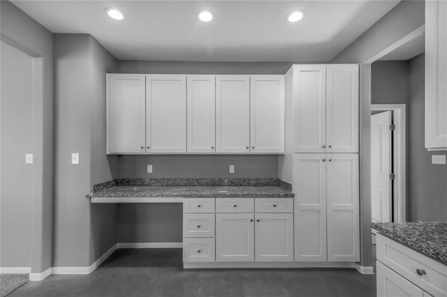 The sleek soft close white cabinets and granite countertops provide a very functional kitchen any family will appreciate. The room has ample storage space and a modern, clean design. | Image 6