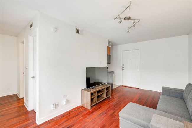 Living room featuring wood finished floors, baseboards, and rail lighting | Image 28