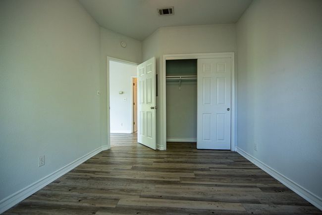Unfurnished bedroom featuring a closet and dark wood finished floors | Image 6