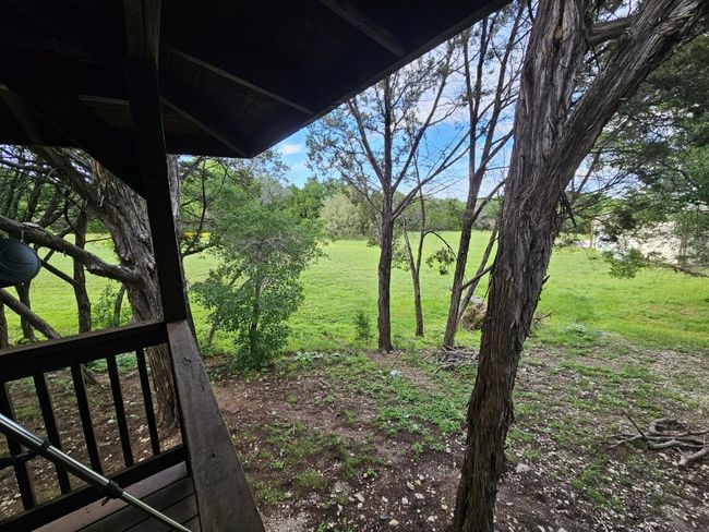 Wrap-Around Porch View of green field beyond the trees | Image 35