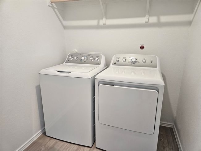 Washroom with baseboards, independent washer and dryer, wood finished floors, and laundry area | Image 15