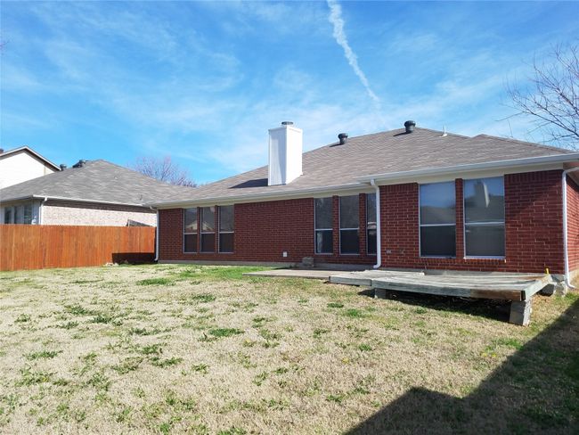 Back of property featuring brick siding, a chimney, and a shingled roof | Image 13