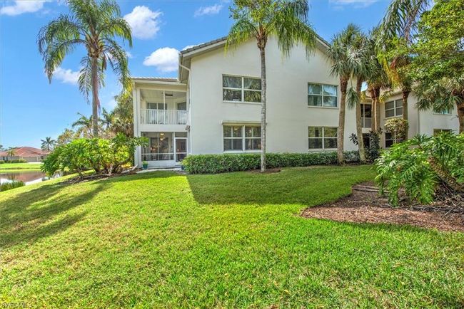Back of house with a tile roof, stucco siding, a balcony, a lawn, and a water view | Image 28