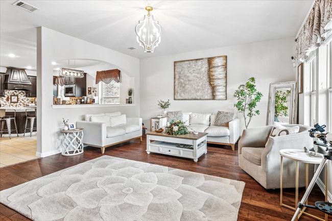 Living area with a chandelier, arched walkways, and wood finished floors | Image 12