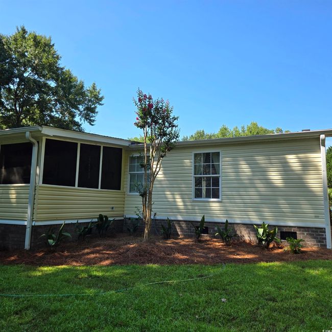 View of home's exterior featuring a yard, a sunroom, and crawl space | Image 36