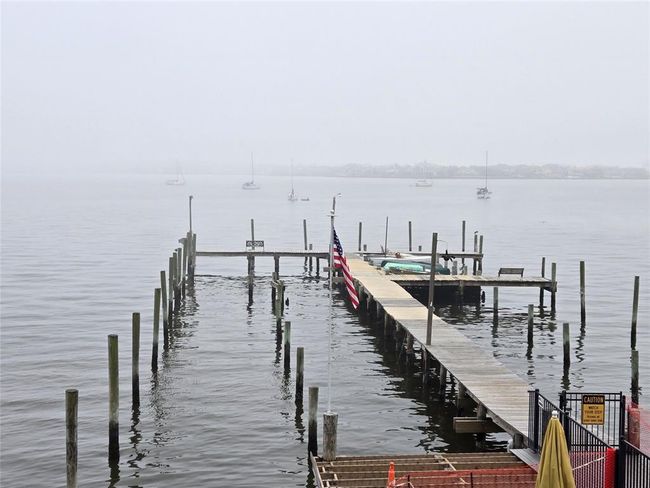 Experience tranquility with this wooden dock overlooking serene waters and distant sailboats—a perfect haven for boating enthusiasts and those seeking a peaceful retreat. | Image 19