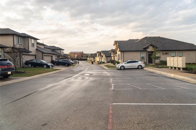 View of asphalt road featuring a residential view and curbs | Image 24
