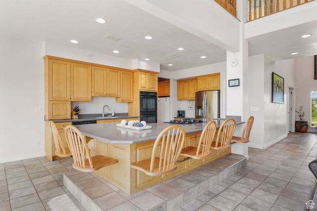 Kitchen featuring a breakfast bar area, stainless steel appliances, recessed lighting, and baseboards | Image 5