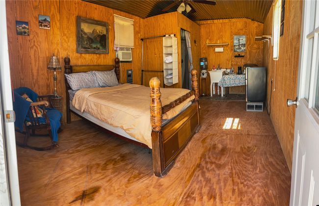 Bedroom featuring wooden walls, wood ceiling, lofted ceiling, and cooling unit | Image 34