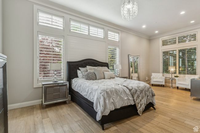 Bedroom featuring ornamental molding, light wood-style floors, a chandelier, and recessed lighting | Image 28