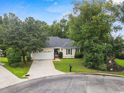 Ranch-style home featuring a garage and a front yard | Image 1