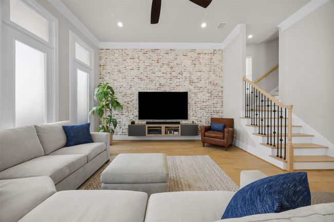 Living room with stairway, ceiling fan, wood finished floors, ornamental molding, and recessed lighting | Image 14