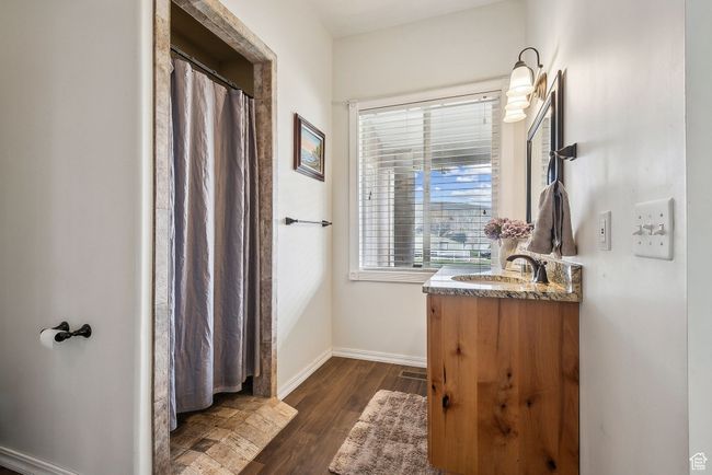 Bathroom featuring baseboards, vanity, and wood finished floors | Image 30