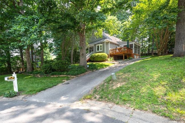 View of property exterior with a yard, a deck, and asphalt driveway | Image 50