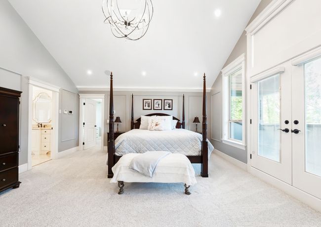 Bedroom featuring french doors, baseboards, vaulted ceiling, and light carpet | Image 23