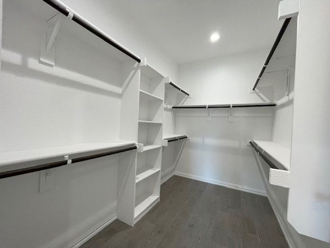Master walk in closet featuring wood-style flooring and lots of storage | Image 18