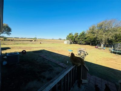 View of yard with a shed, cooling unit, a rural view, and a trampoline | Image 3