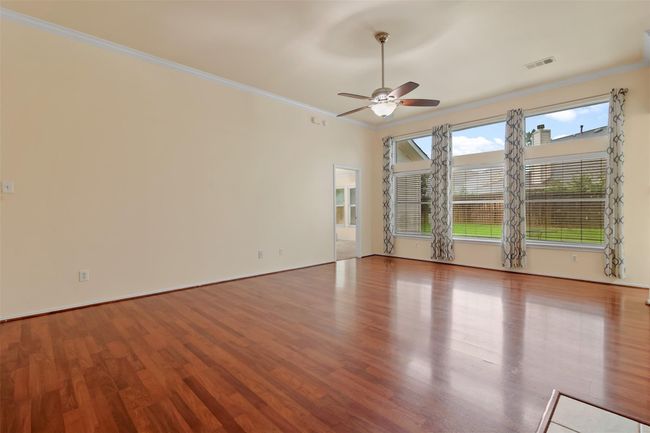 The family room has a whole wall of large picture windows overlooking the backyard. The windows allow for lots of natural light in the home. | Image 7