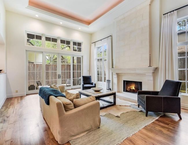 Living room with wood floors, an abundance of natural light, and a fireplace | Image 6