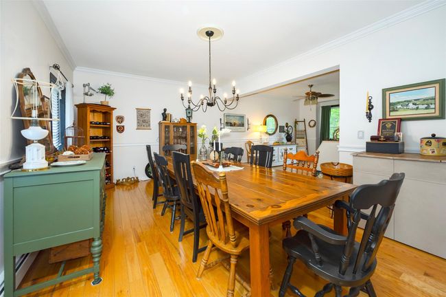 Dining area with ornamental molding, light wood-style floors, a chandelier, and ceiling fan | Image 12