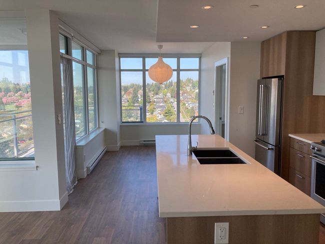 Kitchen featuring a sink, modern cabinets, a healthy amount of sunlight, stainless steel appliances, and light countertops | Image 6