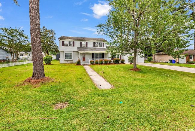 Traditional home with concrete driveway, a garage, a porch, and a front lawn | Image 32