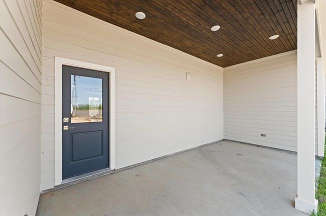 Covered patio with wood-accented ceiling, ideal for grilling or outdoor lounging. | Image 30