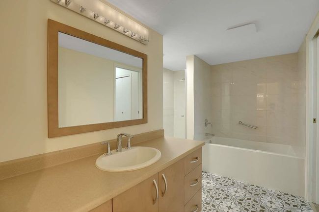 Bathroom with vanity, tile patterned flooring, and bathtub / shower combination | Image 27