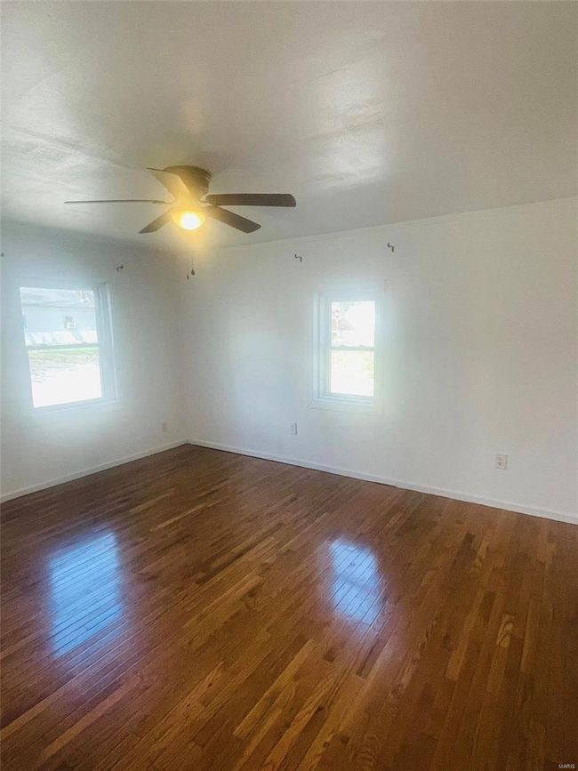 Spare room with baseboards, wood finished floors, and ceiling fan | Image 4