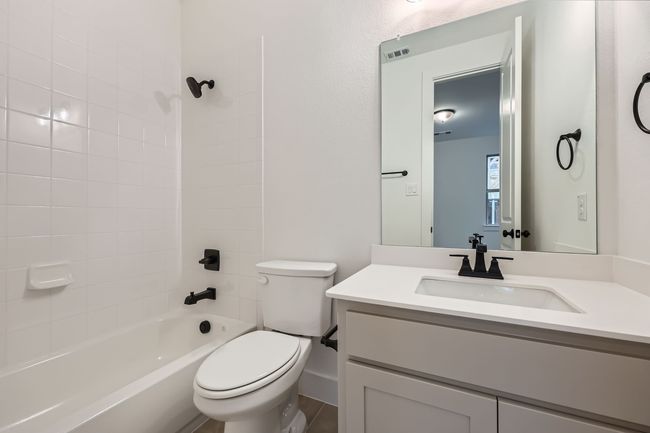 Full bathroom featuring vanity, toilet, shower combination, and visible vents | Image 25