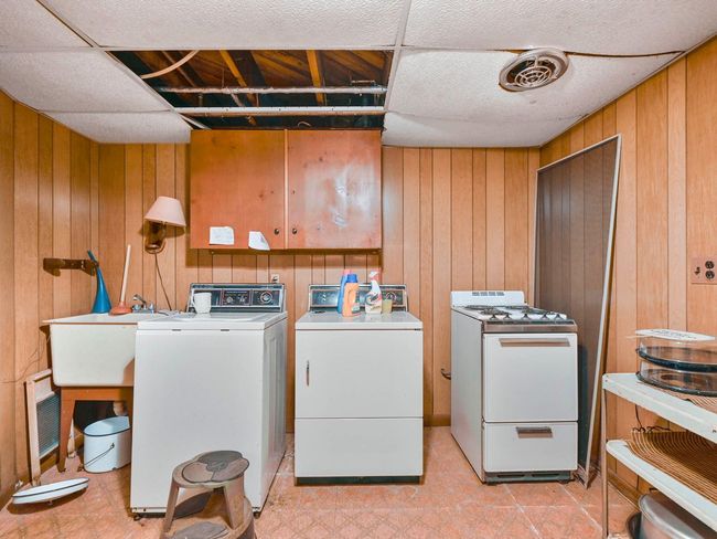 Clothes washing area featuring washing machine and dryer and wooden walls | Image 33