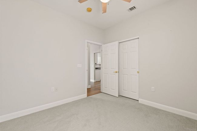 Unfurnished bedroom with light carpet, baseboards, visible vents, and a ceiling fan | Image 28