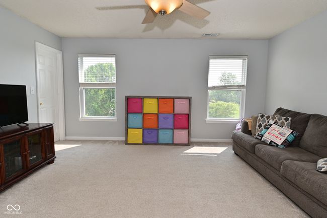 living area with healthy amount of natural light, ceiling fan, carpet floors, and baseboards | Image 29