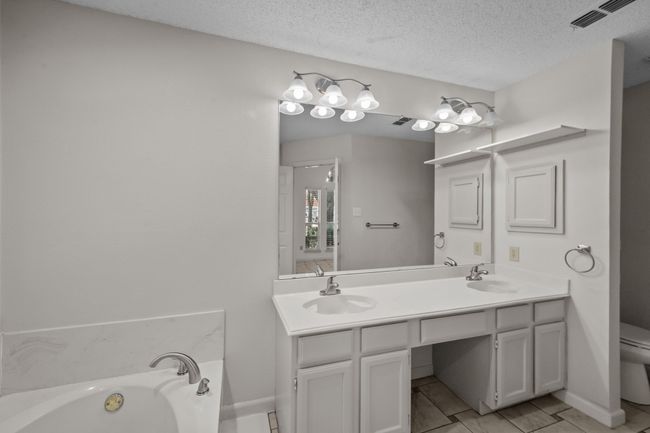 Full bathroom featuring double vanity, a garden tub, and private commode | Image 27
