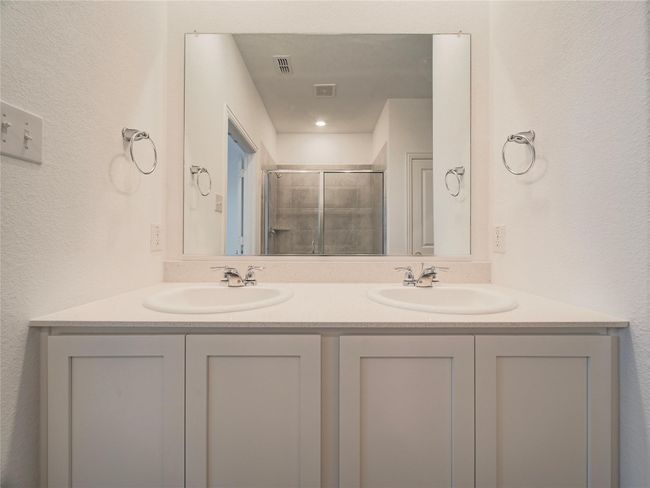 Bathroom featuring double vanity and a shower stall | Image 18