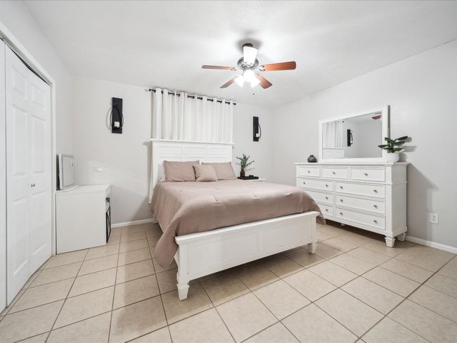 Bedroom featuring light tile patterned floors, baseboards, a ceiling fan, and a closet | Image 12