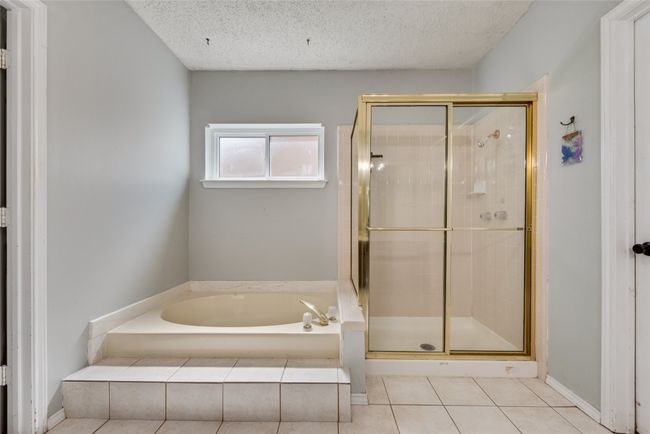 Bathroom featuring a garden tub, a shower stall, a textured ceiling, and tile patterned floors | Image 18