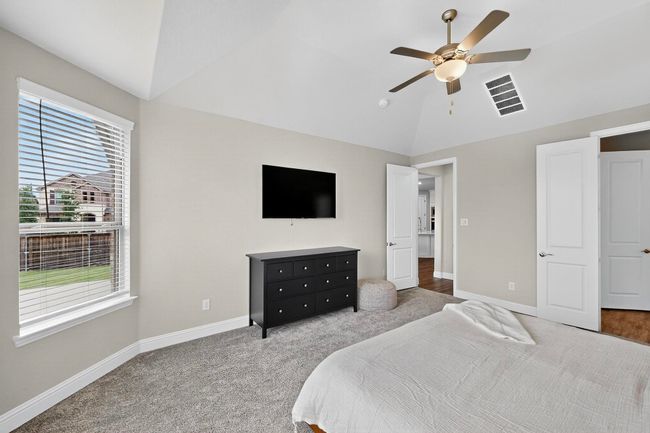 Bedroom with vaulted ceiling, carpet floors, and a ceiling fan | Image 15