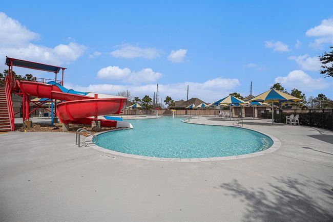 Make a splash in the sparkling neighborhood pool, complete with thrilling red and blue water slides for all-day fun. | Image 34