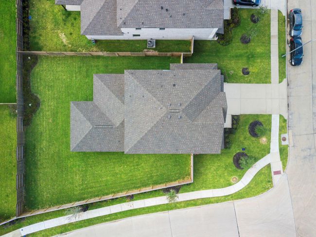 Overhead perspective emphasizes the full layout of the home and spacious yard, complete with privacy fencing, lush green lawn, and a clear view of the impressive Massey Oaks community. | Image 41
