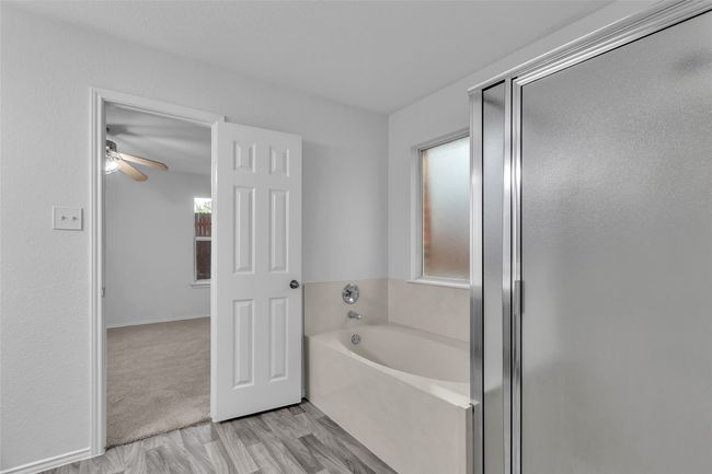 Full bath featuring a bath, ceiling fan, and an enclosed shower | Image 20